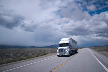 Semi truck with reefer trailer on flat long Arizona road