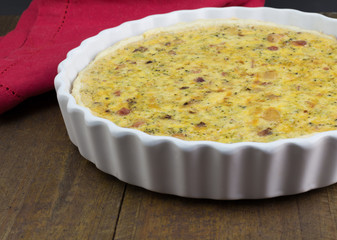 Quiche with cheese, bacon and mushroom on rustic wooden table - Open pie in white dish with selective focus