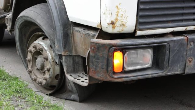 Flat tire of an old fragment of a rusty broken truck