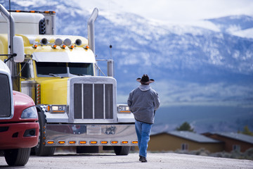 Truck driver going to customized impressive yellow semi truck