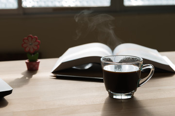 Black coffee cup with steam on office desk  table