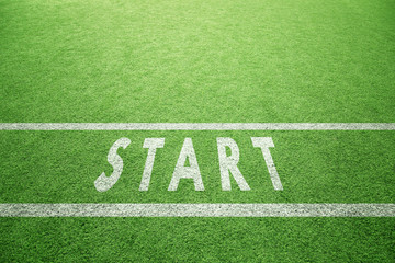 Sunny artificial green grass with painted start line pattern on the ground. © robsonphoto