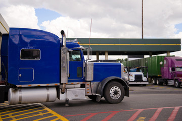 Blue semi truck rig on truck stop side view