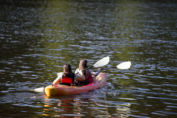 Two girls on kayak paddle at Trillium Lake with reflected in water