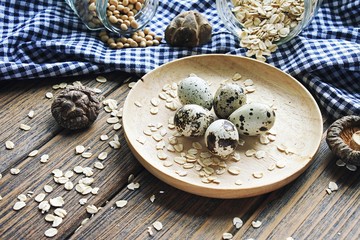 Healthy ingredients for breakfast (Quail eggs, Soy bean, Rolled oat, Mushroom) over wooden background.