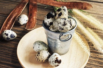 Quail eggs on a wooden plate.