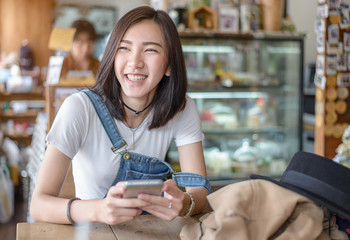 Cute asian girl type text on smartphone in hand ,Social network in hand ,Online business on mobile