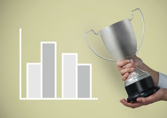 Cropped image of hand holding trophy by graph 