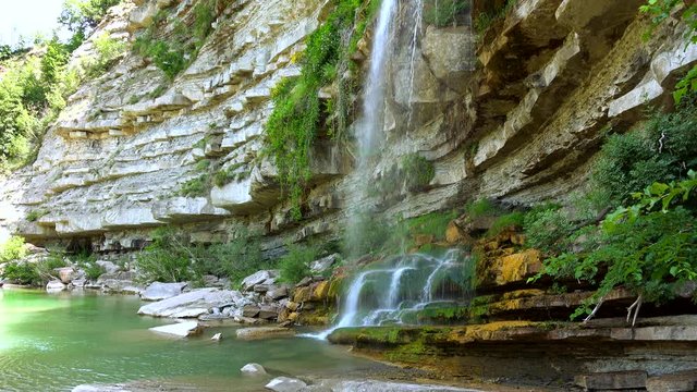 waterfall on sedimentary rocky wall in Italy