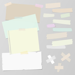 Multiple pieces of sticky tape and different size and shape notepaper on grey background 
