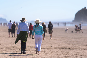 People happily walking along the shore of the Pacific ocean