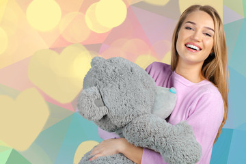 Casual smiling young woman holding teddy bear