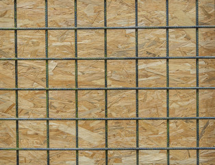 iron mesh net in front of wooden plank close-up