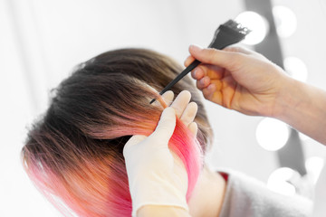 Hairdresser does hair style of woman