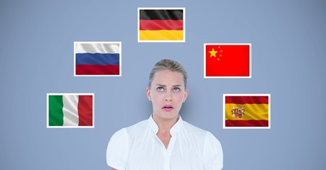 Businesswoman standing by various flags against blue background