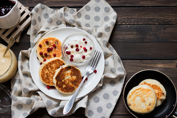 Cheesecakes for breakfast on a dark wooden background