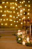 Wedding ceremony decorations in loft grunge surround. Light bulb garland, candles, glass and chairs