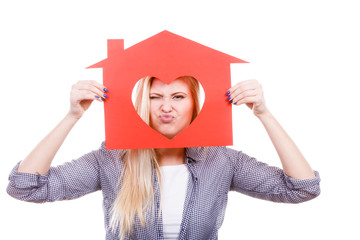 Funny girl holding red paper house with heart shape