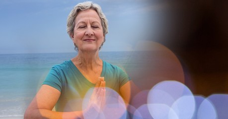 Naklejka premium Senior women meditating on beach against sky