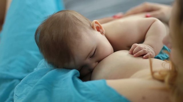 Adorable newborn baby being breastfed by mother