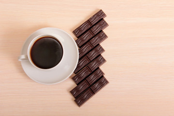 Coffee cup and chocolate on wood table