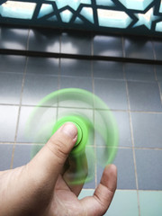 Motion blur, Kid playing with a Tri Fidget Hand Spinner outdoors