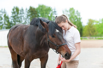 Chestnut horse together with her favorite owner young teenage girl