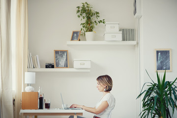 Caucasian freelancer using laptop in modern home office