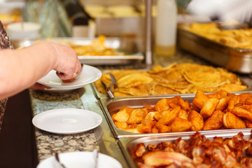 The visitor puts food in his plate