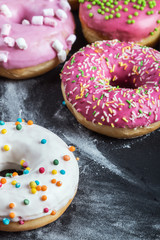 Donuts in a glaze assorted on a black background
