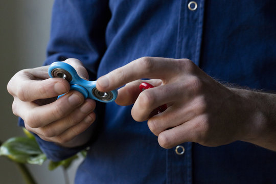 A person holding popular fidget spinner toy