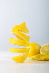 Naklejka na ściany i meble Flying lemon. Sliced lemon on white background. Levity fruit floating in the air.