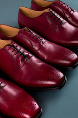 Red oxford shoes on blue background. Three pair  brogues. Close up