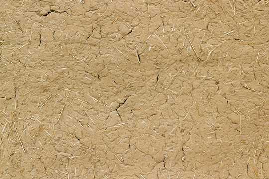 Old clay wall cracked straw background