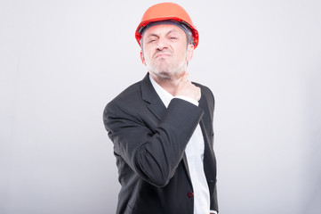 Angry contractor wearing hardhat making cutting neck gesture