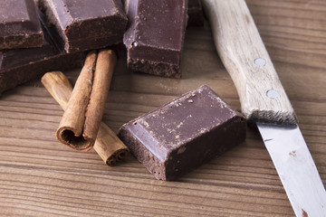 Chocolate and cinnamon on wooden background