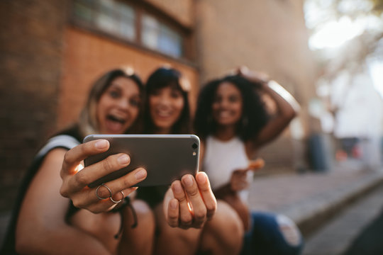 Female friends making selfie with mobile phone
