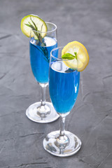 blue curacao cocktail with rosemary, lime and lemon
