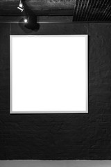 Empty square frame on black brick wall. Blank space poster or art frame waiting to be filled. Square Black Frame Mock-Up