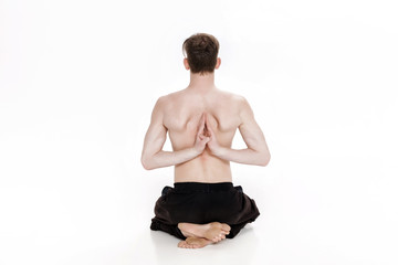 Fototapeta premium Young man doing yoga exercises. Studio shot on white background