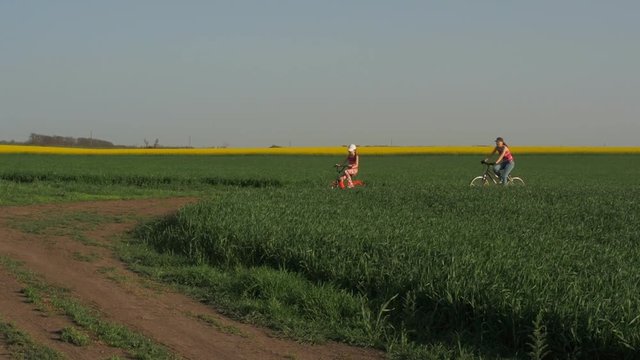 A sports family on bicycles in the countryside. Parents with children ride on bicycles.