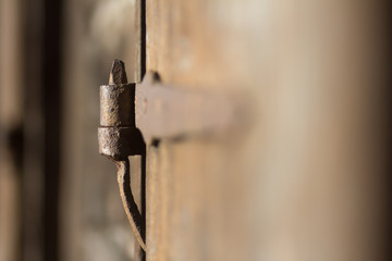 Old rusted hinge of old wooden door.