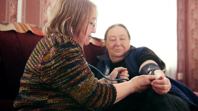 Women pensioners - checking health state with manometer - measures pressure, pensioners healthcare