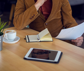 Businessman in a coffee shop reading a contract document