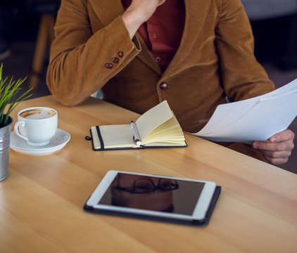 Businessman in a coffee shop reading a contract document