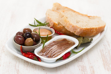 anchovies, olives, bread and fish pate on dish