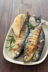 grilled sardines with bread on dish