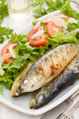 grilled sardines with salad on white dish