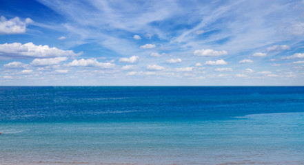 sandy beach shore with blue sea waters and cloudy sky banner