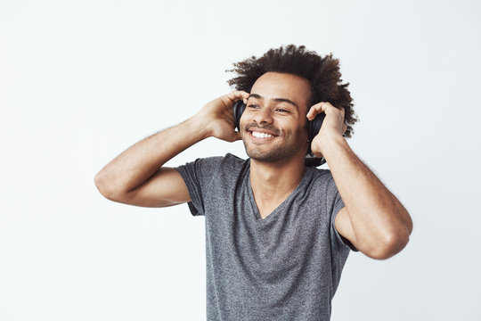 Happy African Man Smiling Listening To Music In Headphones. White Background.